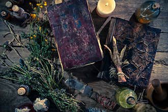 A witchery stuff: multiple tincture bottles, bunches of dry healthy herbs, stack of ancient ritual books, amulets, candles...