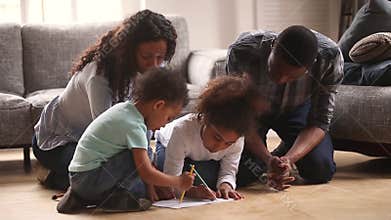 Happy black mom dad and kids drawing together at home