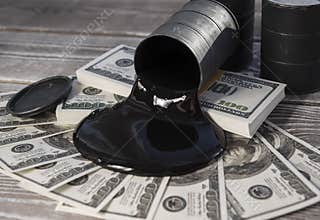 Spilled oil from a barrel to a dollar bill of money.