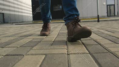 The man legs in shoes walk on the pavement closeup
