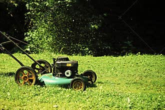 Landscape gardening and landscaping concept. Lawn mower on green grass on sunny day in natural background