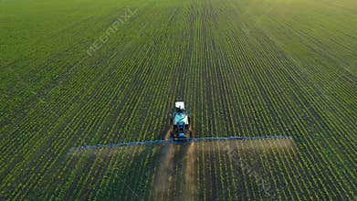 4K aerial drone footage. Following tractor sprayer on soybean fields