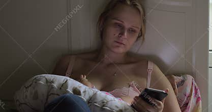 Woman browsing social media during breastfeeding baby