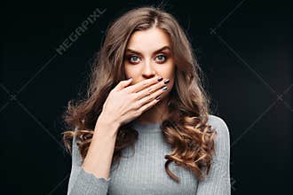 Amazed lovely woman covering mouth with hand