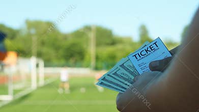 A man thinks the money he won against the backdrop of the stadium where he plays football, sports betting, close-ups