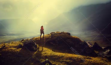 Discovery Travel Destination Concept. Hiker Woman With Backpack Rises To The Mountain Top Against Backdrop Of Sunset Vintage Toned