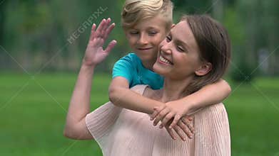 Unmarried mother looking after son in park, embracing beloved child, adoption