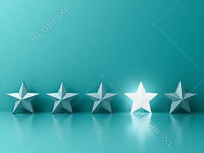 Stand out from the crowd and different creative idea concepts One glowing light star standing among other dim stars on green