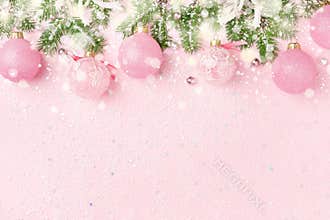 Christmas border of New Year`s ornaments and snow on pink backgr