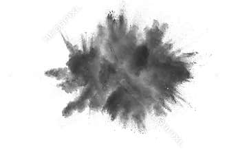 Black powder explosion. The particles of charcoal splatter on white background. Closeup of black dust particles splash isolated on