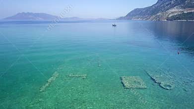 Aerial drone bird`s eye view photo of tourists snorkeling above old Sunken City of Epidauros, Greece
