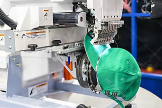 Hat sewing at modern and automatic high technology embroidery machine for textile - clothing apparel making manufacturing process