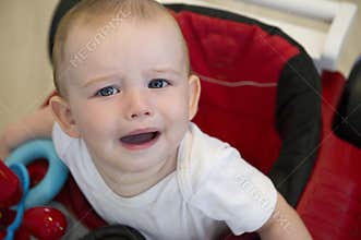Unhappy baby in red walker