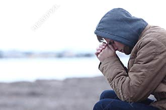 Sad boy complaining in winter on the beach