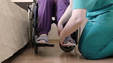 Nurse caring of elder disabled woman in wheelchair