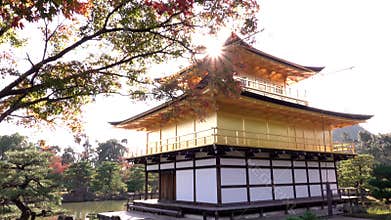 Sun over Golden Pavilion Kinkaku-ji during momiji season, Kyoto, Japan