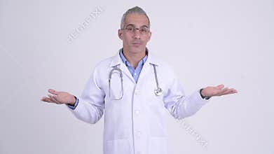 Confused Persian man doctor shrugging shoulders