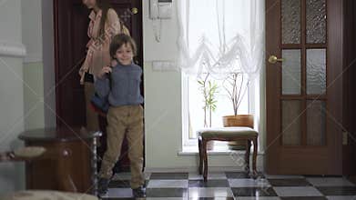 Young girl and little brother with backpack entering the house. Children are happy to back home, boy is smiling. Kids as