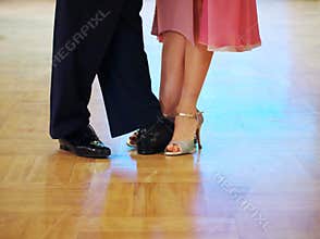 Graceful dance couple tangoing at the ballroom.