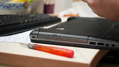 Technician Installing Battery into Laptop