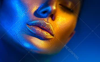 Fashion model woman face in bright sparkles, colorful neon lights, beautiful sexy girl lips. Trendy glowing gold skin makeup