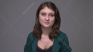 Closeup shoot of adult attractive brunette female nodding saying yes looking at camera with background isolated on gray