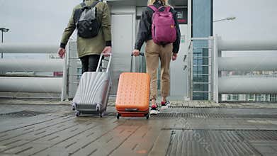 Back view of walking passengers with suitcases, approaching to lift