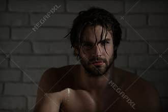 Sexy man with wet hair, muscular body in bath, shower
