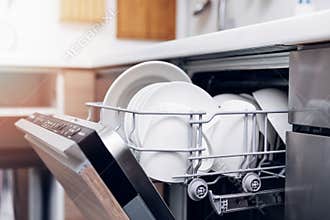 Open dishwasher with clean dishes at home kitchen