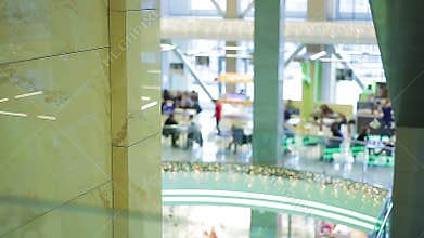 Defocused silhouettes of people having lunch at fast food cafe in shopping mall