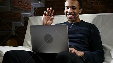 Web Video Chat on Laptop by African Man at Night, Headphones