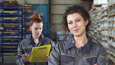 Beautiful cheerful female factory worker smiling to the camera