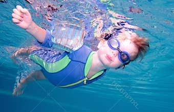 Young boy swimming underwater and holding breath