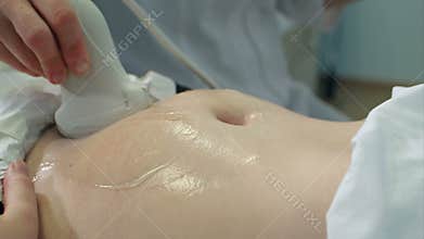 Doctor moving ultrasound probe on pregnant woman`s stomach