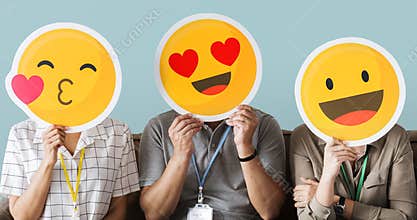 Workers holding happy face emojis