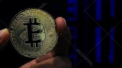 Cryptocurrency mining. Man holding BTC bitcoin coin.