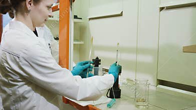 Motion to woman scientist installing examination tools with pipes