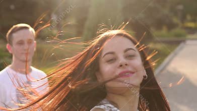 Happy young loving couple dancing a slow waltz at sunset in the park.