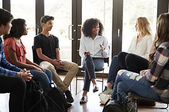 Female Tutor Leading Discussion Group Amongst High School Pupils