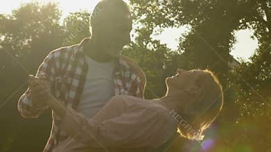 Senior married couple dancing during magic hour, love and happiness emotions