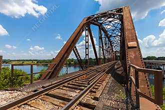 Old rusty truss railroad bridge over the Red River on the border