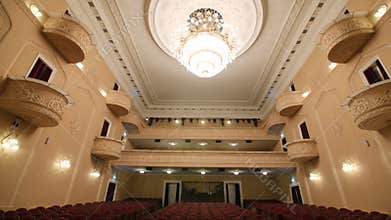 Auditorium of old theater with armchairs and balconies