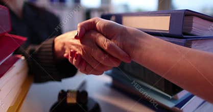 Lawyer or judge shaking hands with client in courtroom with gavel
