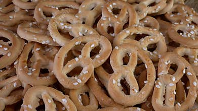 Pile of pretzels sprinkled with sesame rotate on a turntable.
