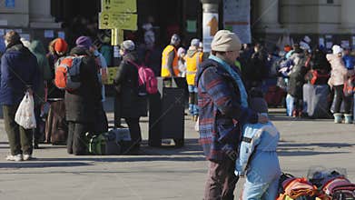 Lviv, Ukraine - March 15, 2022: Ukrainian mother and son refugees standing on Lviv railway station waiting for train to