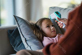 Grandmother taking care of her ill grandchild lying on sofa