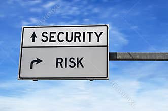 Road sign with words security versus risk. White two street signs with arrow on metal pole. Directional road Crossroads Road Sign