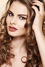 Beautiful model touch her long shiny curly hair
