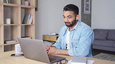 Young indian latin student in glasses speaking watching online webinar.