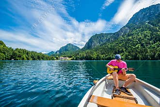 A handsome man is is having a genuine beautiful moment on a little boat in the lake